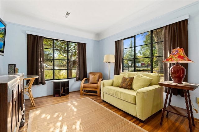 living room featuring visible vents, a healthy amount of sunlight, and wood finished floors