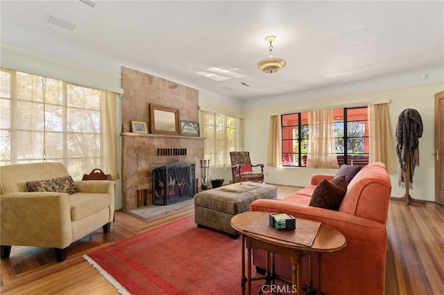 living area featuring wood finished floors, plenty of natural light, and a fireplace