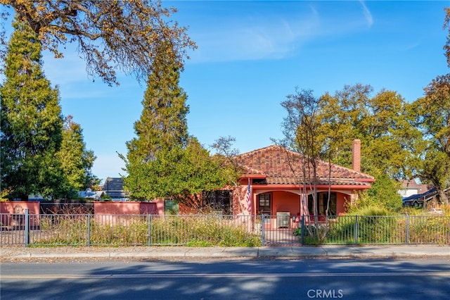 view of front of home with a fenced front yard, stucco siding, and a tile roof