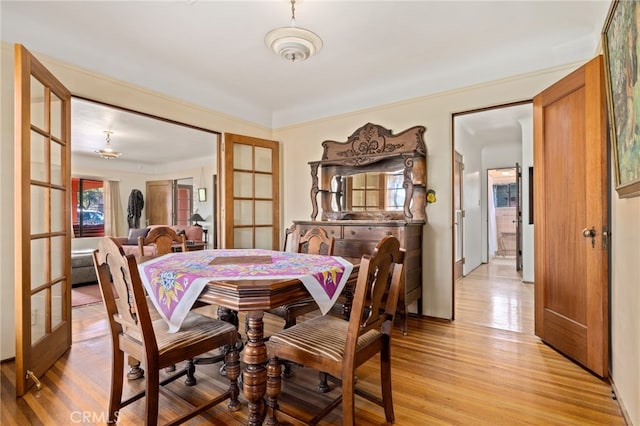 dining area with light wood-style flooring and french doors