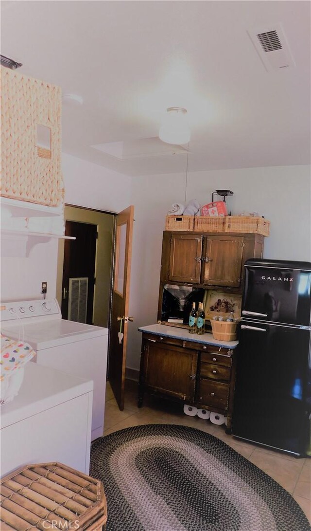 laundry room with light tile patterned floors, visible vents, and laundry area