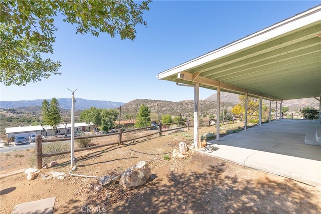 view of yard featuring fence and a mountain view