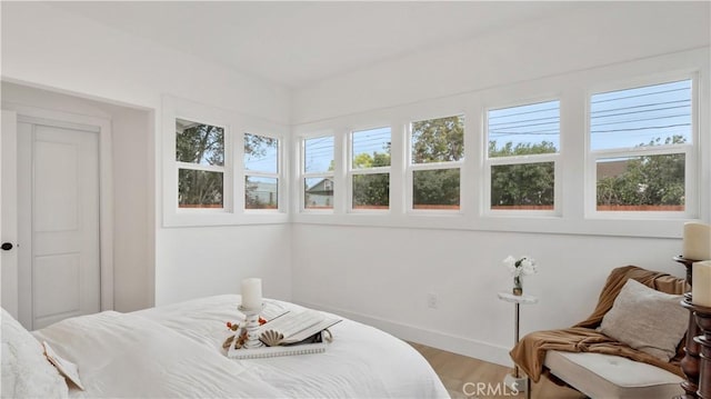 bedroom featuring baseboards and light wood finished floors