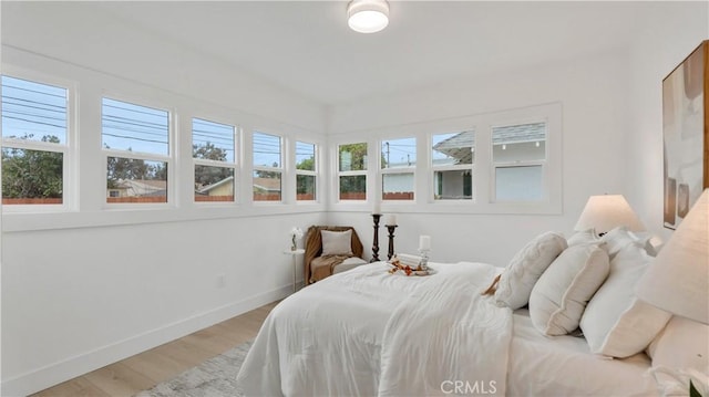 bedroom featuring light wood-style flooring and baseboards