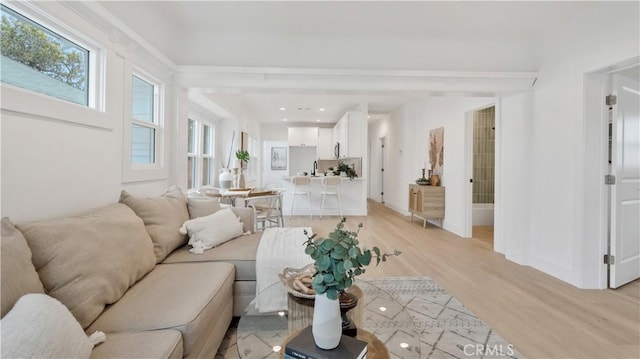 living area with baseboards and light wood-type flooring