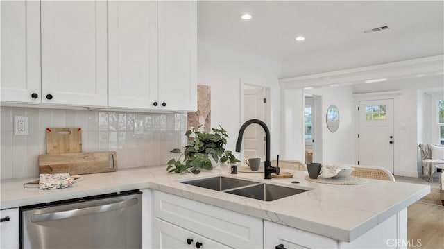 kitchen featuring visible vents, white cabinetry, a peninsula, a sink, and dishwasher