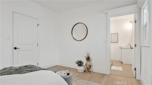 bedroom with light wood-type flooring and baseboards