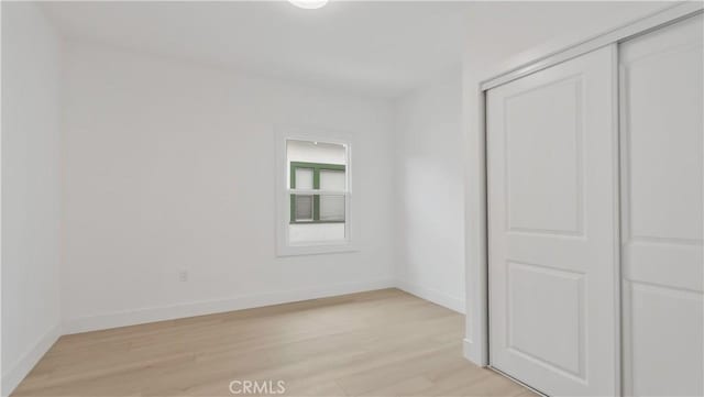 unfurnished room featuring light wood-style floors and baseboards