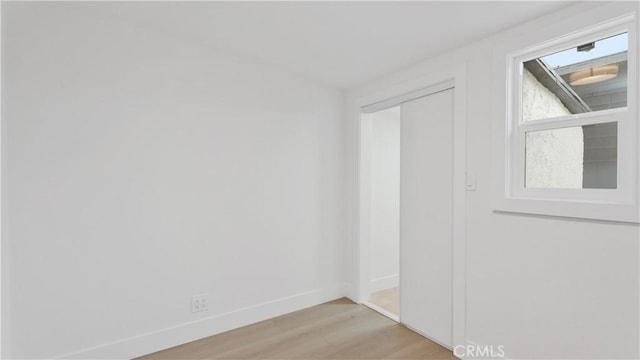 empty room featuring light wood-style floors and baseboards