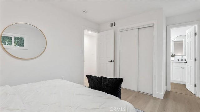 bedroom with visible vents, a closet, and light wood-type flooring