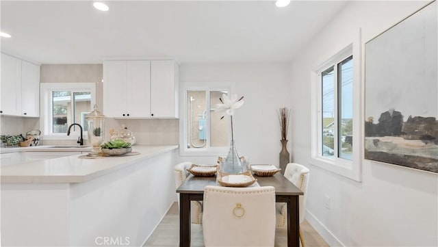 dining room featuring light wood-style flooring, recessed lighting, and baseboards