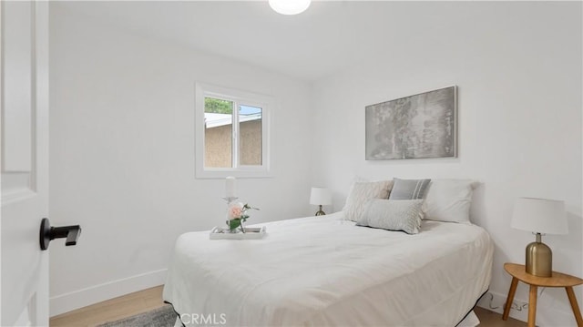 bedroom with baseboards and wood finished floors