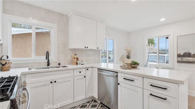 kitchen with a healthy amount of sunlight, a peninsula, stainless steel appliances, and a sink