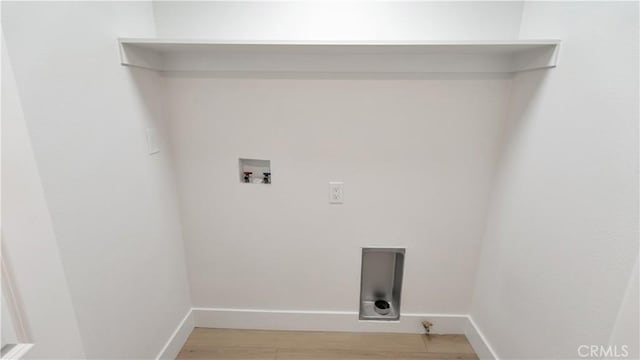 washroom featuring baseboards, light wood-style floors, hookup for a washing machine, and laundry area