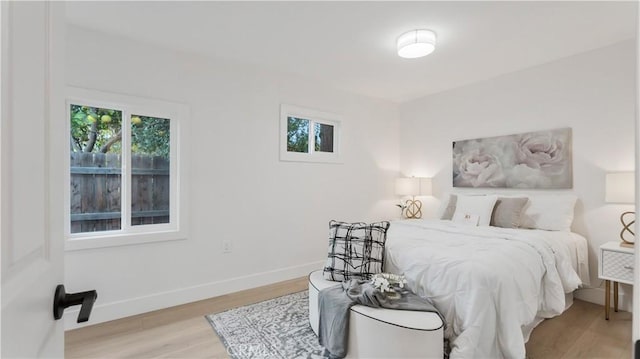 bedroom with wood finished floors and baseboards