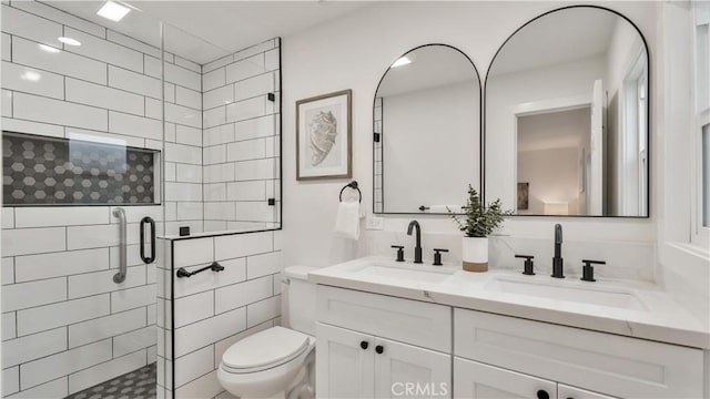 bathroom featuring a shower stall, toilet, and a sink