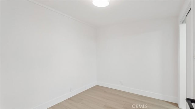 spare room featuring light wood-style flooring and baseboards