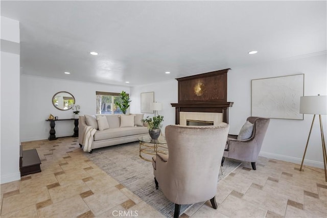 living room featuring recessed lighting, baseboards, and a large fireplace