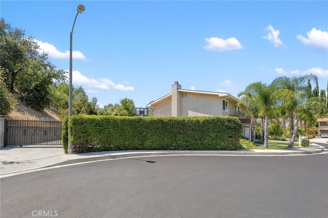 view of side of property with a gate and stucco siding