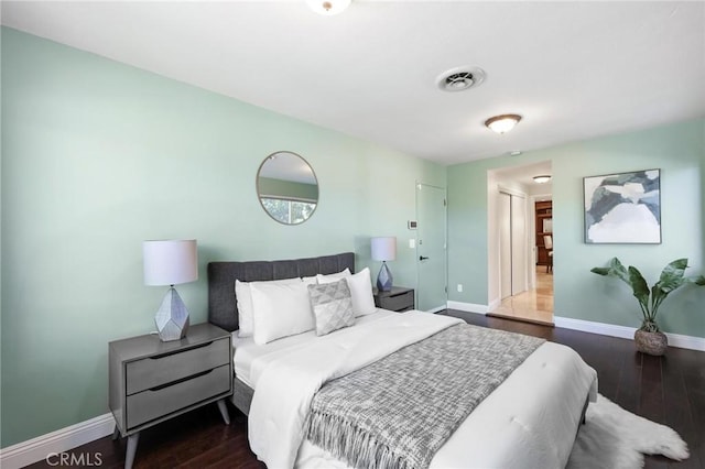 bedroom featuring visible vents, baseboards, and wood finished floors