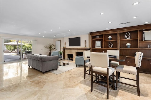 dining space featuring recessed lighting, visible vents, marble finish floor, and a fireplace