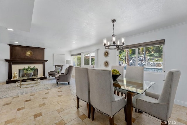 dining space with a textured ceiling, recessed lighting, a fireplace, baseboards, and a chandelier