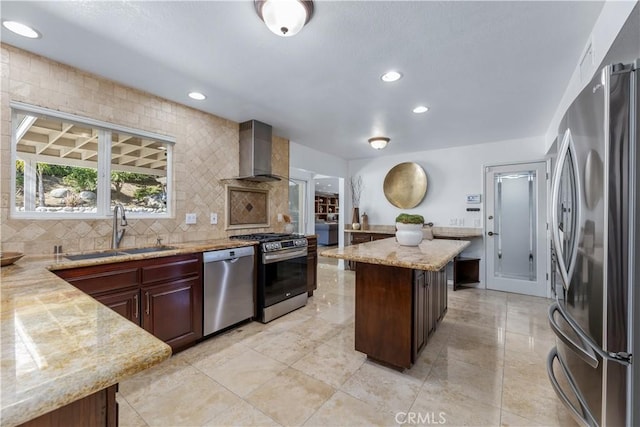 kitchen with a sink, tasteful backsplash, recessed lighting, stainless steel appliances, and wall chimney exhaust hood