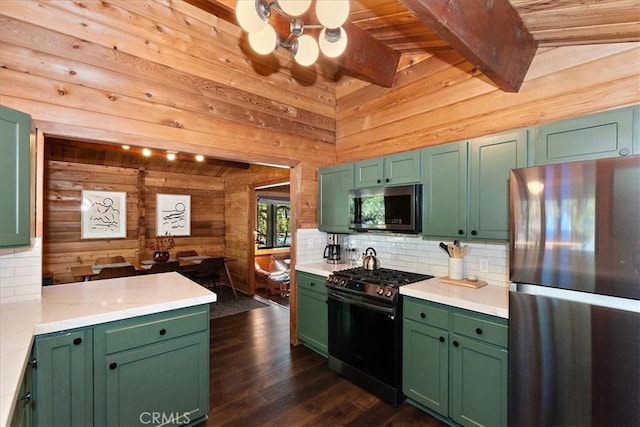 kitchen featuring wooden walls, appliances with stainless steel finishes, and green cabinets