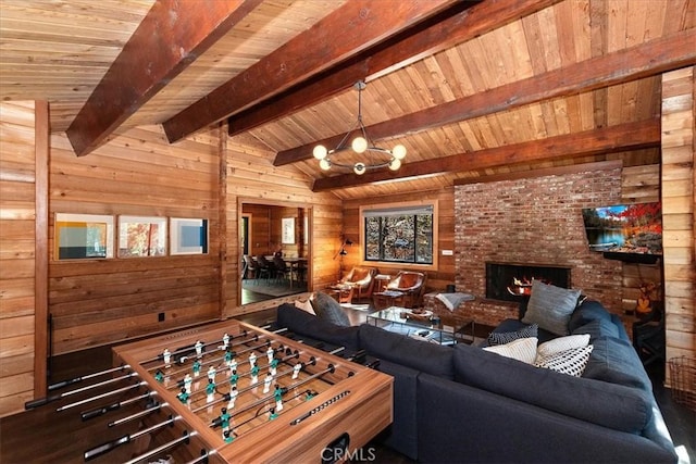 playroom with a notable chandelier, wooden walls, wooden ceiling, a fireplace, and vaulted ceiling with beams