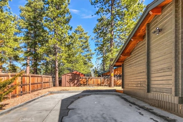 view of patio featuring a storage unit, an outbuilding, and a fenced backyard