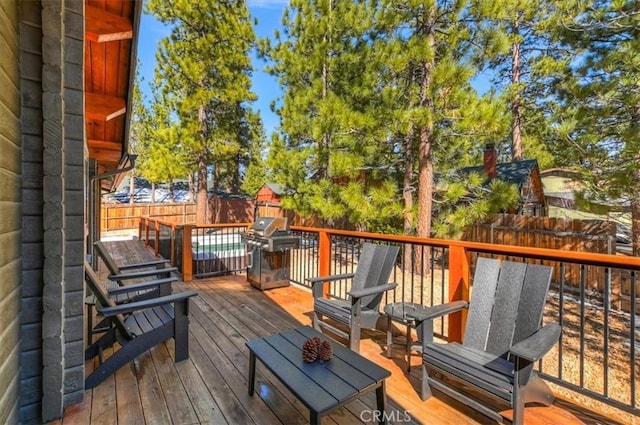 wooden terrace featuring a fenced backyard and grilling area