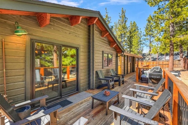 wooden terrace with fence and a grill