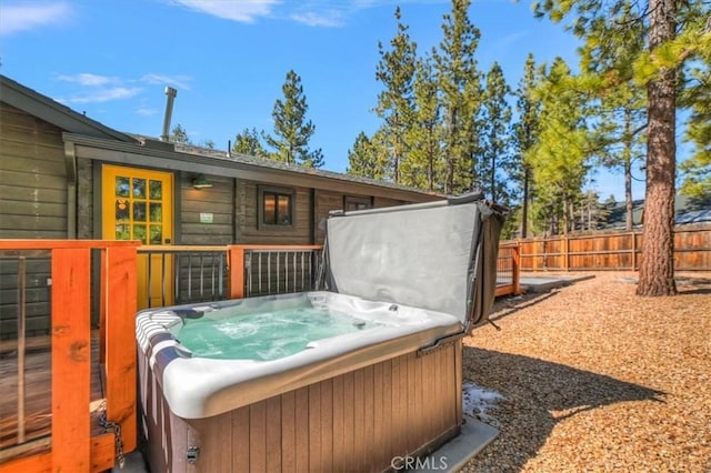 exterior space with fence and a hot tub