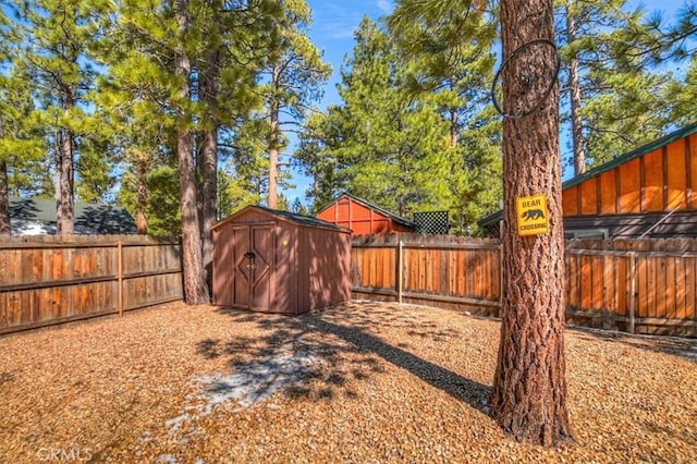 view of yard with a fenced backyard, an outdoor structure, and a shed