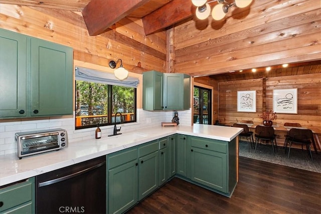 kitchen with a sink, lofted ceiling with beams, wood walls, dishwasher, and dark wood-style flooring