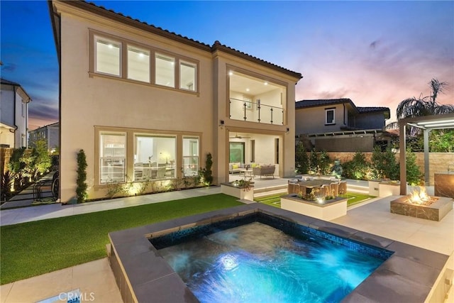 20535 W Bluebird Ct, Porter Ranch, CA 91326 - back of house featuring stucco siding, a patio, an outdoor living space with a fire pit, and an in-ground hot tub