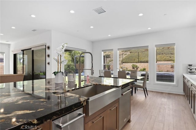 20535 W Bluebird Ct, Porter Ranch, CA 91326 - kitchen with recessed lighting, stainless steel dishwasher, a sink, dark stone countertops, and light wood-type flooring