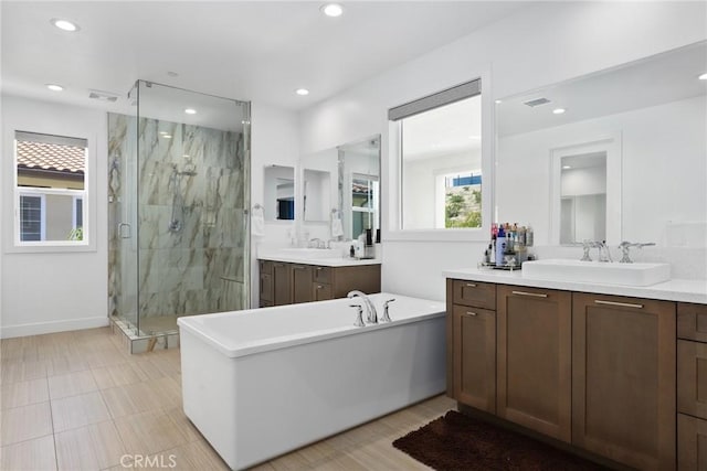 20535 W Bluebird Ct, Porter Ranch, CA 91326 - bathroom with a marble finish shower, recessed lighting, two vanities, a freestanding bath, and baseboards