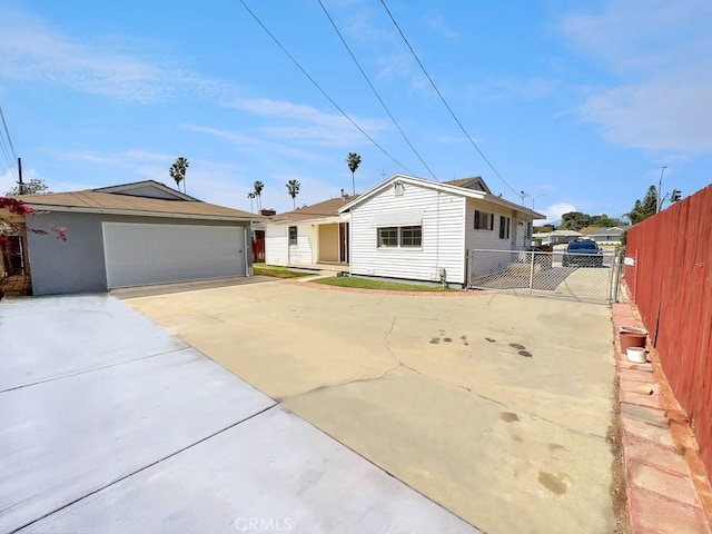 ranch-style home with concrete driveway, a gate, fence, and a garage