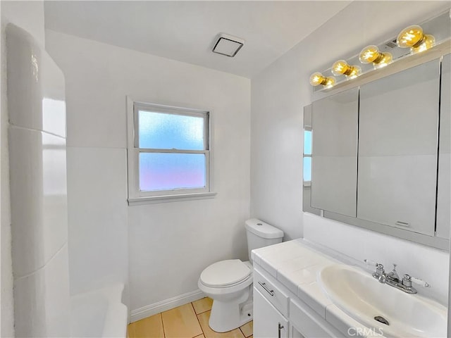 bathroom with tile patterned flooring, toilet, vanity, and baseboards