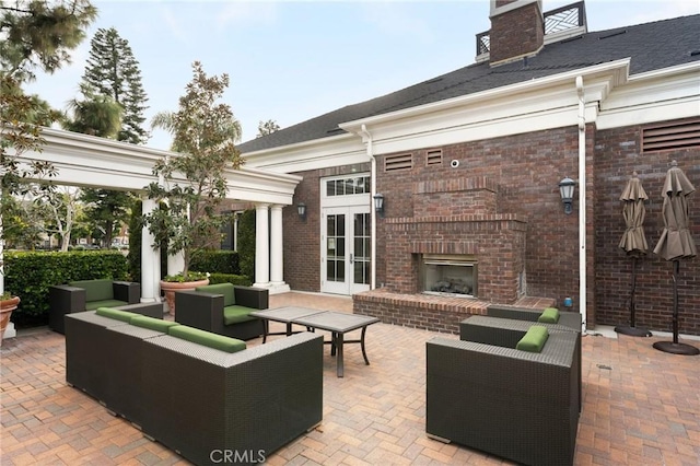 view of patio with an outdoor living space with a fireplace and french doors