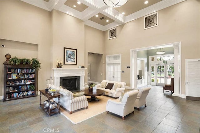 living room featuring beamed ceiling, visible vents, coffered ceiling, a glass covered fireplace, and french doors