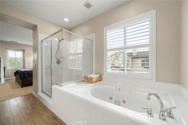 ensuite bathroom with visible vents, connected bathroom, a stall shower, and a tub with jets