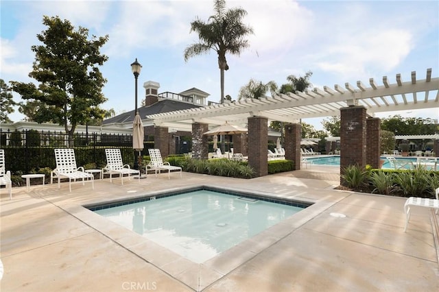 community pool with a patio and a pergola