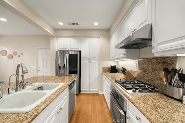 kitchen with visible vents, a sink, light wood-style floors, appliances with stainless steel finishes, and under cabinet range hood