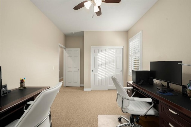 office featuring light colored carpet, baseboards, and ceiling fan