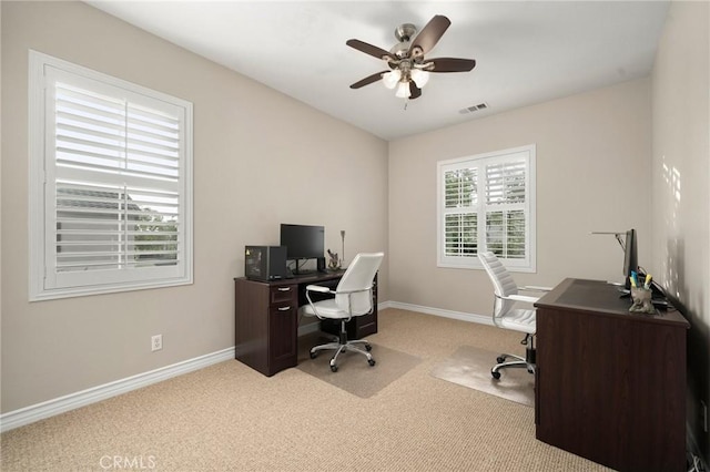 carpeted office space with visible vents, baseboards, and a ceiling fan