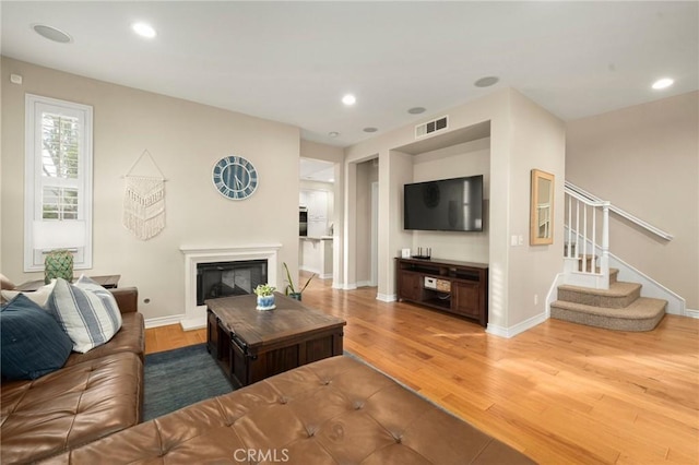 living room featuring light wood-style flooring, recessed lighting, and visible vents