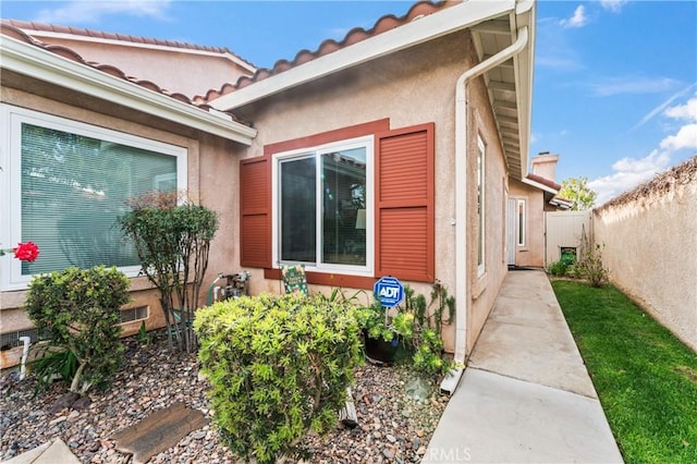 entrance to property with fence and stucco siding