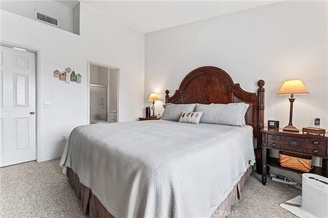 carpeted bedroom with visible vents and connected bathroom